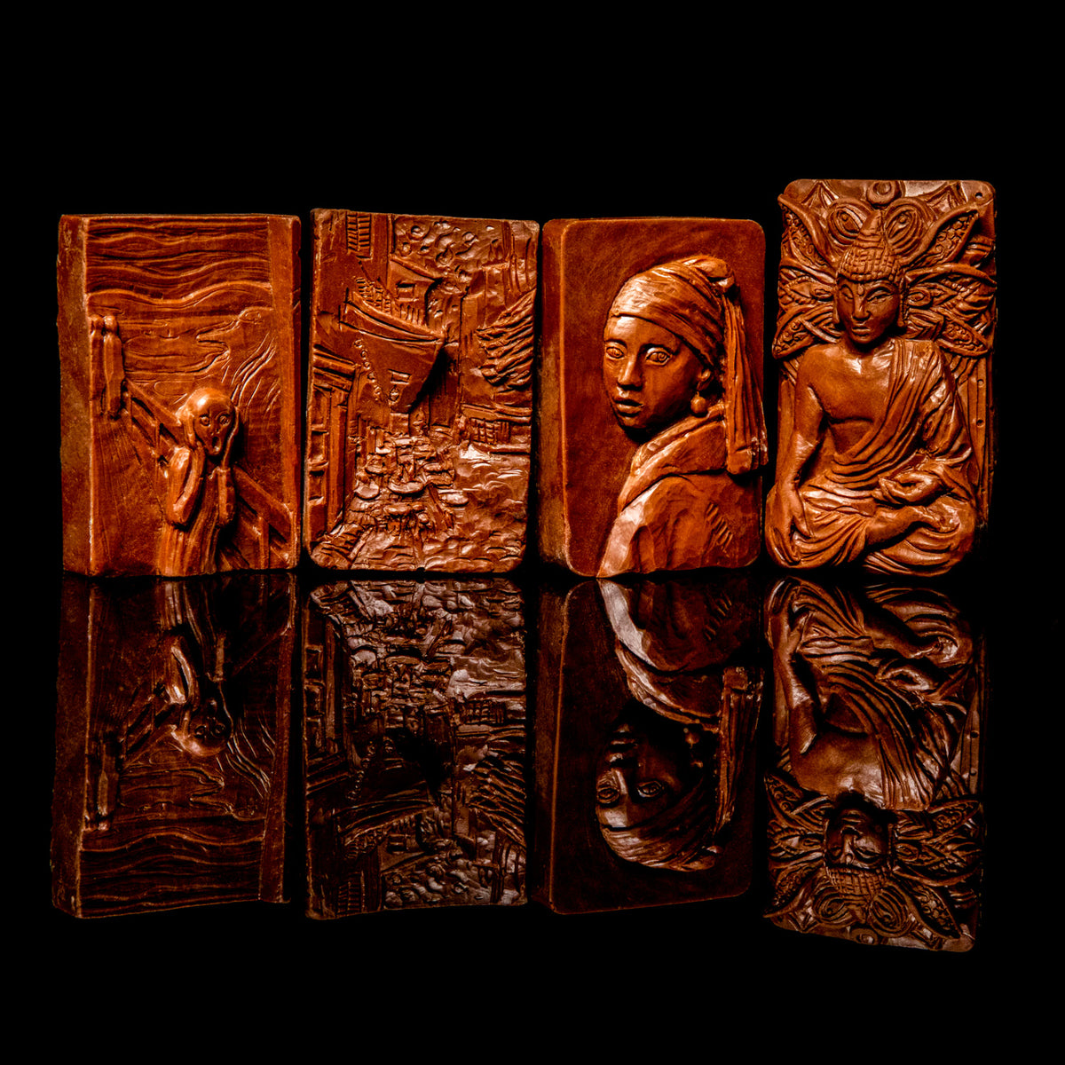 Four milk chocolate art bars with embossed relief designs displayed in a row: The Scream with expressive figure, Girl with a Pearl Earring portrait, Cafe Terrace with street scene, and Sitting Buddha with meditative figure, shown against a black background